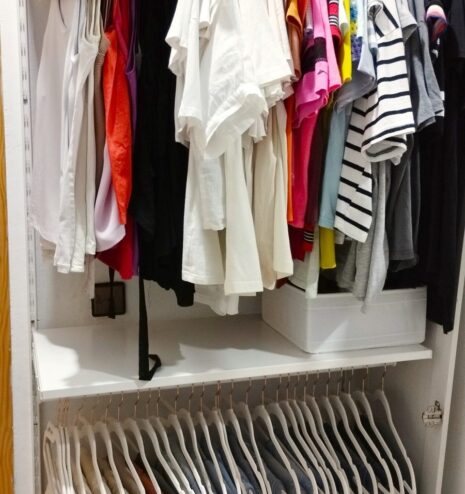 Ropa colgada y ordenada por color en un vestidor organizado en Madrid