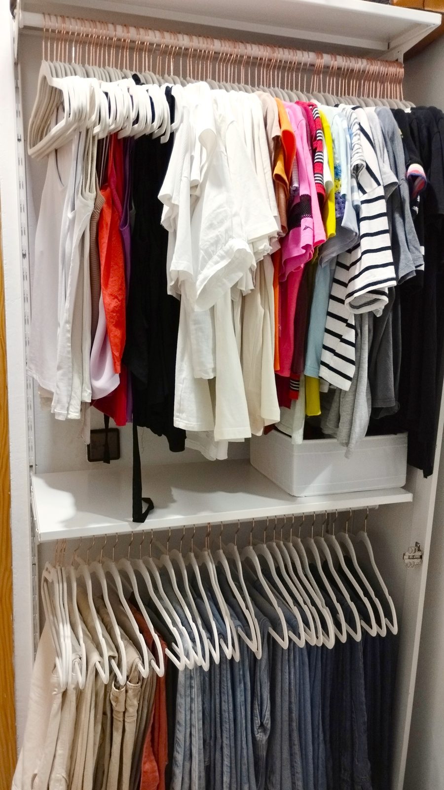 Ropa colgada y ordenada por color en un vestidor organizado en Madrid