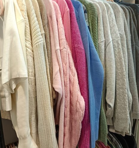 Prendas de punto colgadas y ordenadas por color en un vestidor