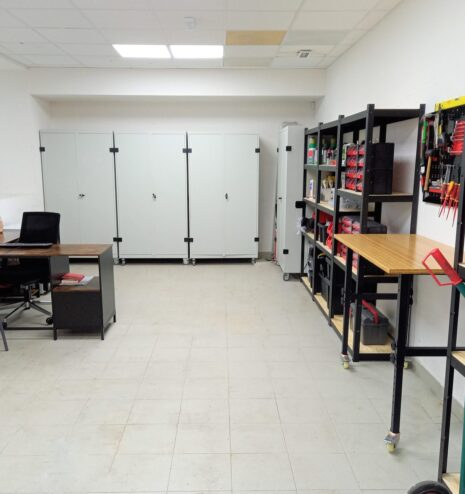 Almacén de empresa organizado con estanterías y zona de trabajo