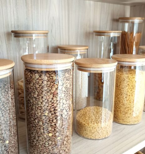 Botes de cristal con legumbres y cereales en una despensa organizada