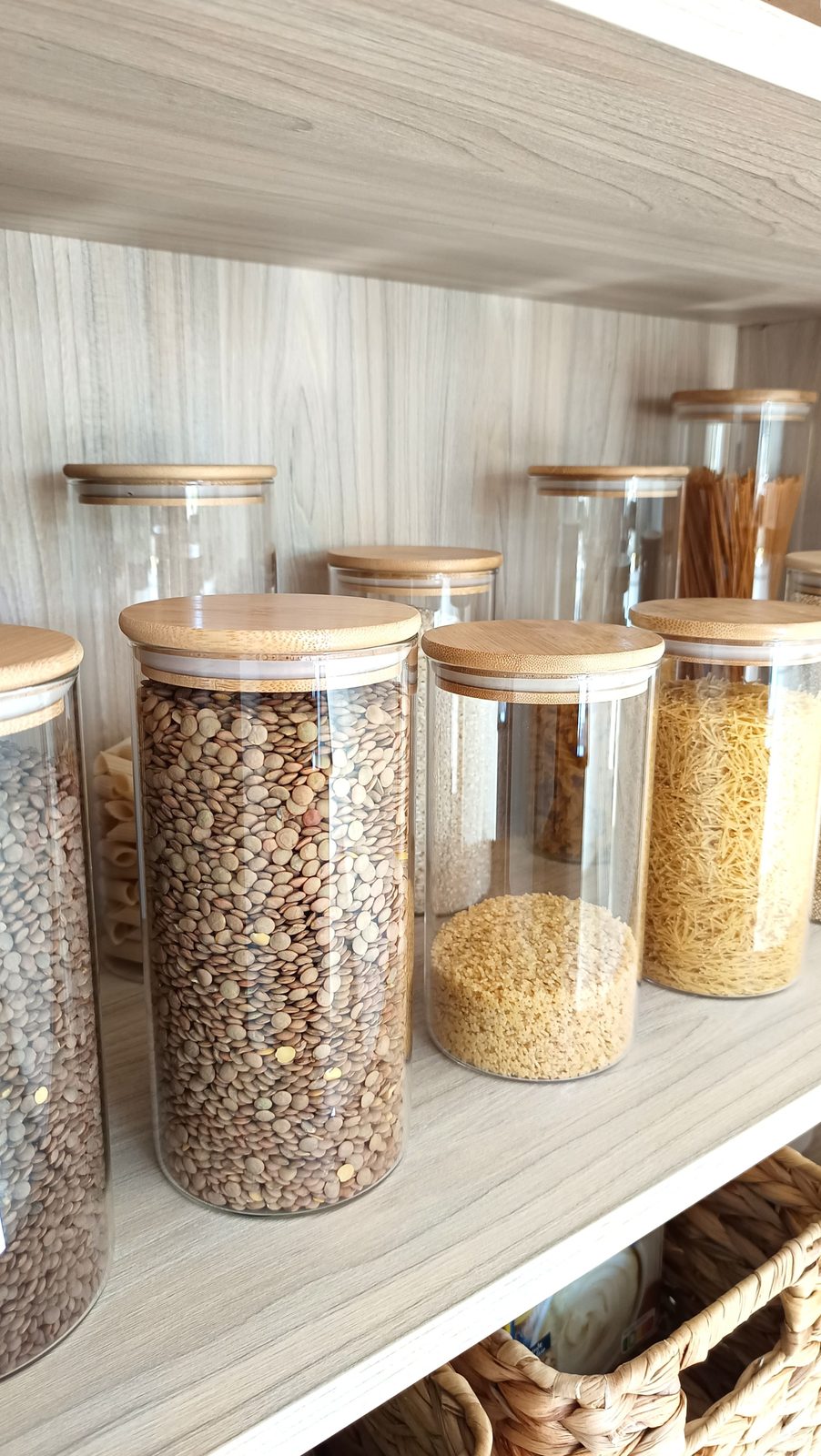 Botes de cristal con legumbres y cereales en una despensa organizada